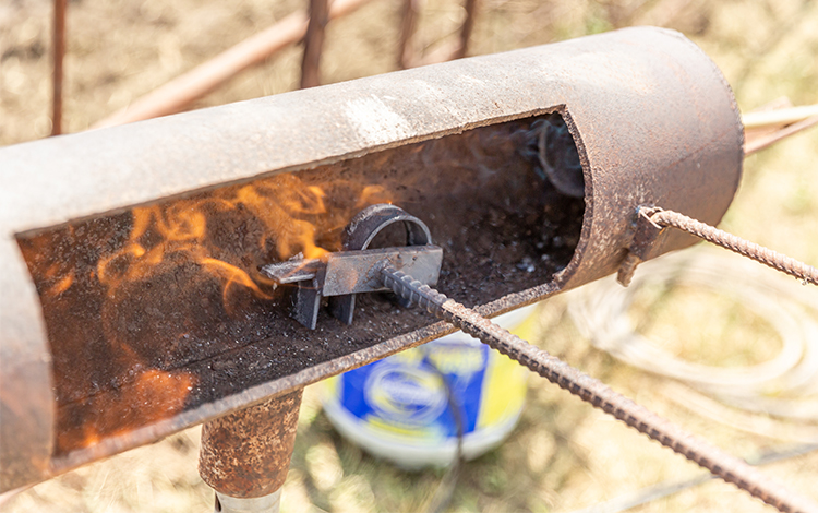 Person heats branding tool in fire